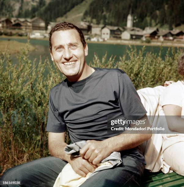 Italian actor and director Alberto Sordi smiling by a lake. 1960s.