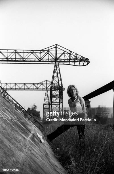 Italian TV presenter and actress Gabriella Farinon posing leaning her leg on a wall. Italy, 1968.