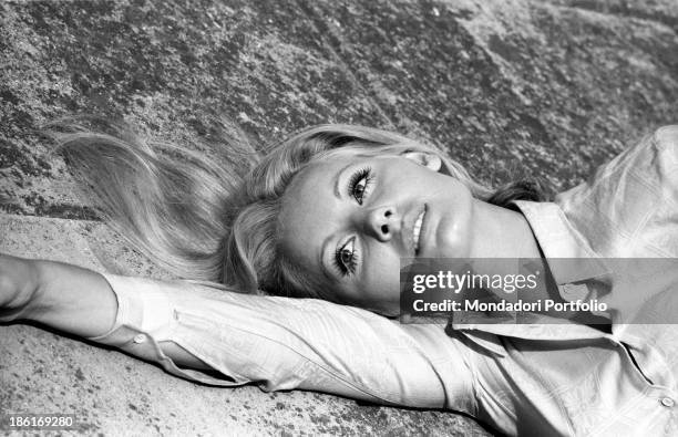 Italian TV presenter and actress Gabriella Farinon posing lying down. Italy, 1968.