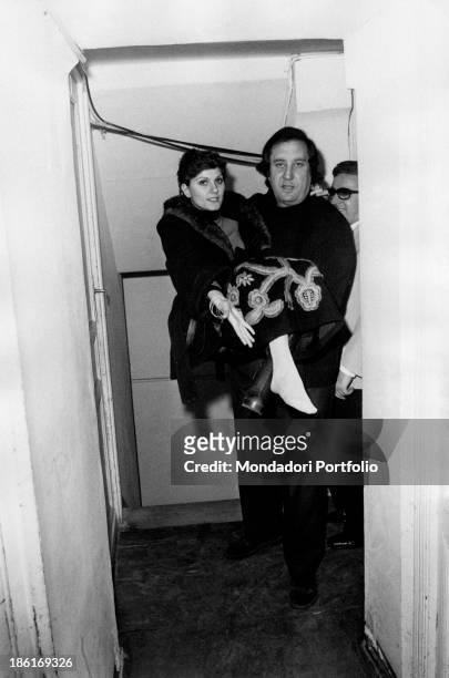 Italian singer and composer Corrado Lojacono holding Italian singer Gilda Giuliani showing her bound foot. 1974 .