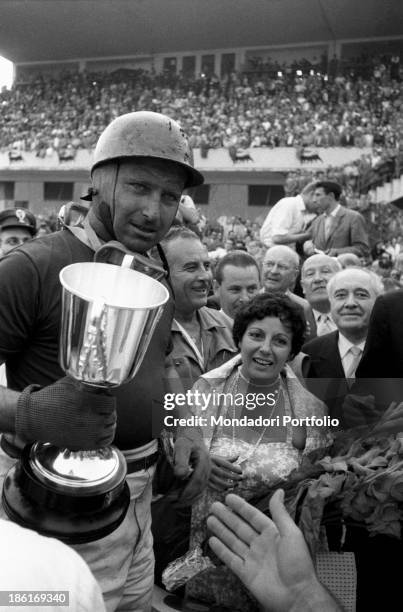 Argentinian racing driver Juan Manuel Fangio looking satisfied because he was the first to cross the finishing line at the 6th Italian Grand Prix....