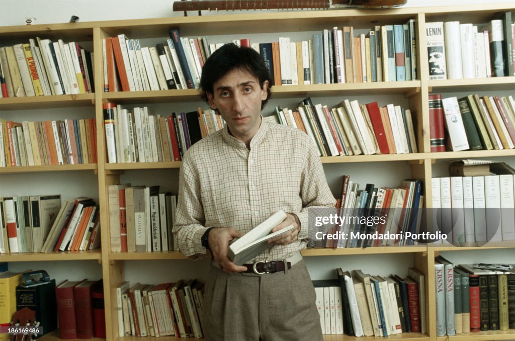 Franco Battiato in front of a bookcase