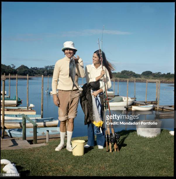 South African surgeon Christiaan Barnard showing a freshly caught fish under the pleased gaze of his wife Barbara Zoellner. Plettenberg Bay, 1977.