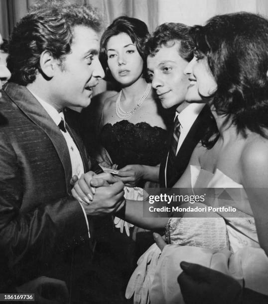 Italian singer-songwriter and actor Domenico Modugno shaking hands with Italian-born French singer and actress Dalida while French record producer...