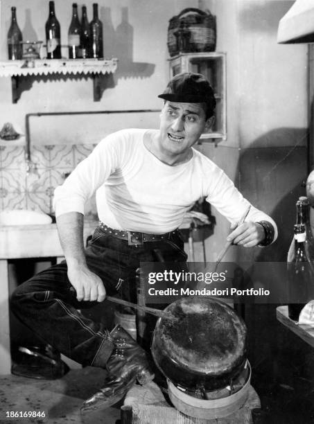 Italian actor and director Alberto Sordi playing a pan with two wooden spoons in the film An American in Rome. 1954.