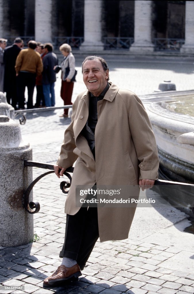 Alberto Sordi sitting beside a fountain on Piazza San Pietro