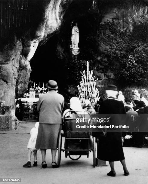 Believers praying in the Grotto of Massabielle during the centenary of the apparitions of Our Lady to Saint Bernadette Soubirous. Lourdes, 22nd...