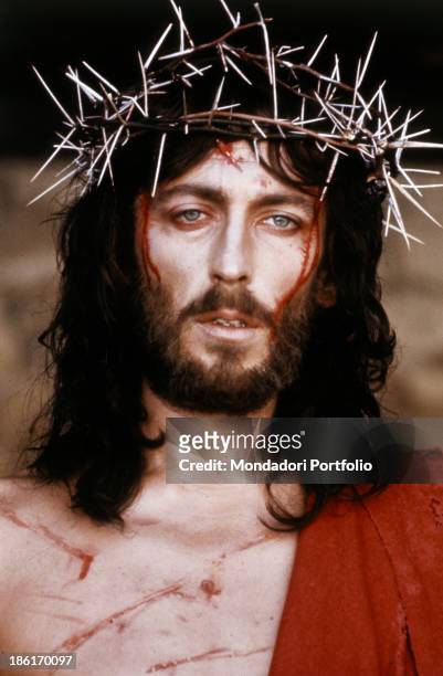 Close up of the English actor Robert Powell acting Jesus Christ, in the television miniseries 'Jesus of Nazareth'. He wears a crown of thorns and he...