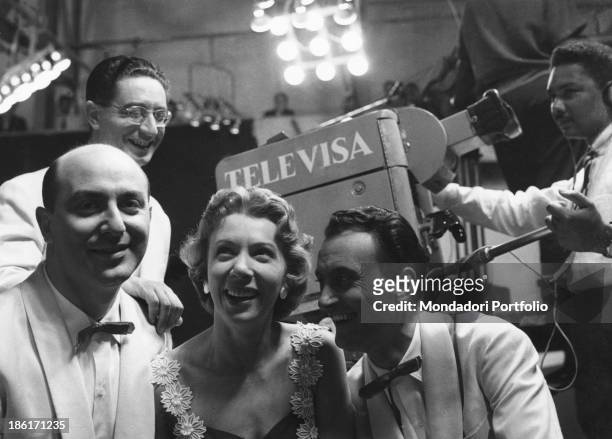 Members of the Quartetto Cetra smiling in front of a Televisa camera. The band is formed by Italian singer and drummer Felice Chiusano, Italian...