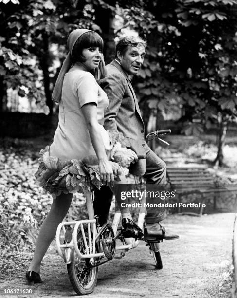 The actor Ugo Tognazzi and the dancer and singer Maria Grazia Buccella sitting on a tandem on the set of the movie Dismissed on His Wedding Night....