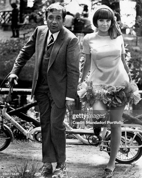 The actor Ugo Tognazzi and the dancer and singer Maria Grazia Buccella pose next to a tandem bycicle on the set of the movie Dismissed on His Wedding...