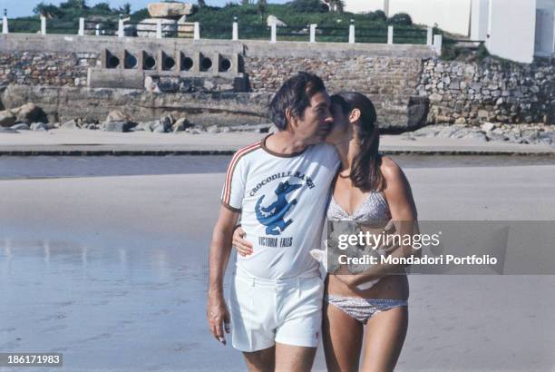 South African surgeon Christiaan Barnard hugging his wife Barbara Zoellner by the sea. Plettenberg Bay, 1977.