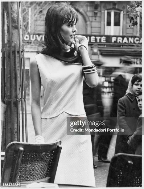 Model wearing a two-pieces dress made of white smocking piquet by French fashion collection. 1960s.