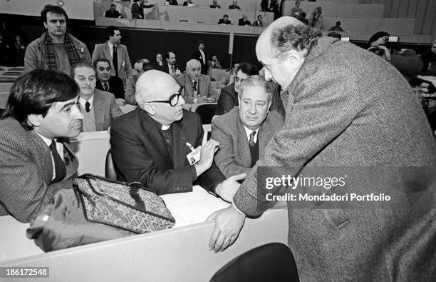 The National Secretary of the Christian Democracy Ciriaco De Mita, leaning against one of the benches at the XVI Congress of the party, talks with...