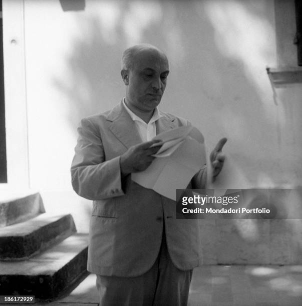 Italian politician and General Secretary of the Christian Democratic Party Amintore Fanfani reading something. He's spending holidays with his...