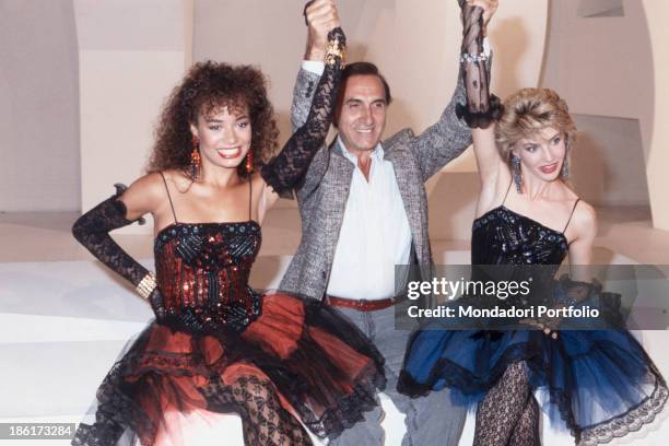 Italian TV presenter Pippo Baudo raising the arms of Italian showgirl and dancer Lorella Cuccarini and American actress and dancer Galyn Gorg in the...