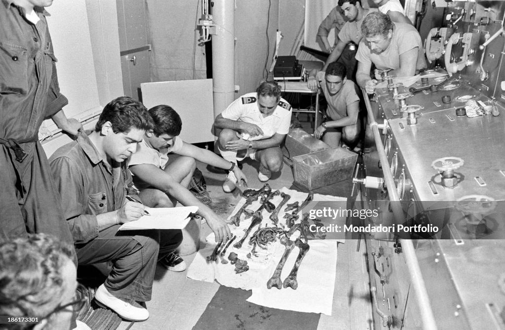 The crew of the submarine rescue ship Anteo examinating the bones found inside t