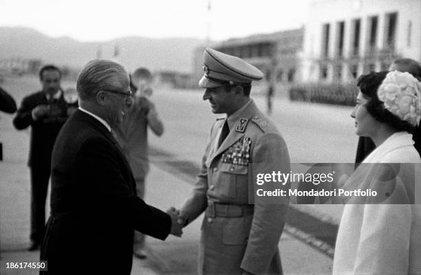 Italian politician and President of the Italian Republic Giovanni Gronchi shaking hands with the Shah of Iran Mohammad Reza Pahlavi. Behind them, Her...