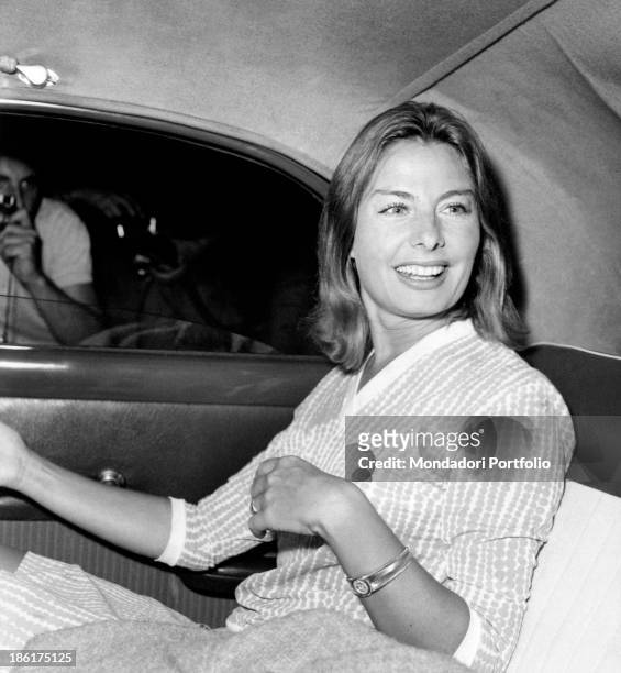 Maria Cristina Vettore Austin sitting in a car and smiling. Maria is the American tycoon Henry Ford II's partner. 1963.