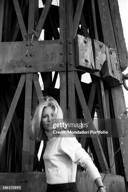 Italian TV presenter and actress Gabriella Farinon posing near a pylon. Italy, 1968.