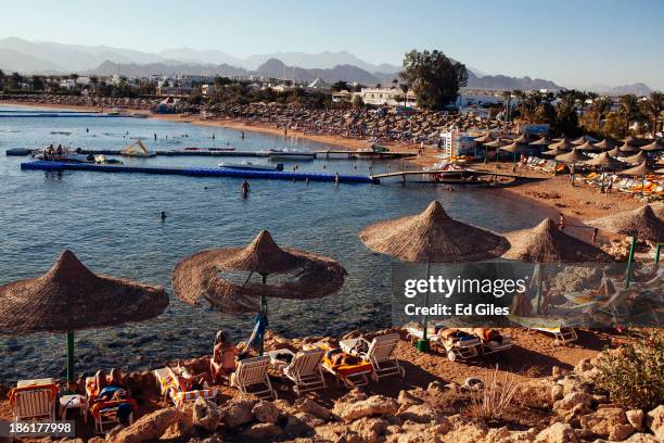 People relax on beach chairs at a beach popular with tourists on October 26, 2013 in the Red Sea resort town of Sharm El Sheikh, Egypt. Sharm...