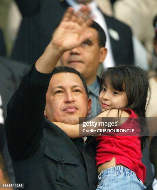 Venezuelan President Hugo Chávez holds a child as he arrives at a benefit function in Caracas, Venezuela 19 December 2002. El presidente venezolano...