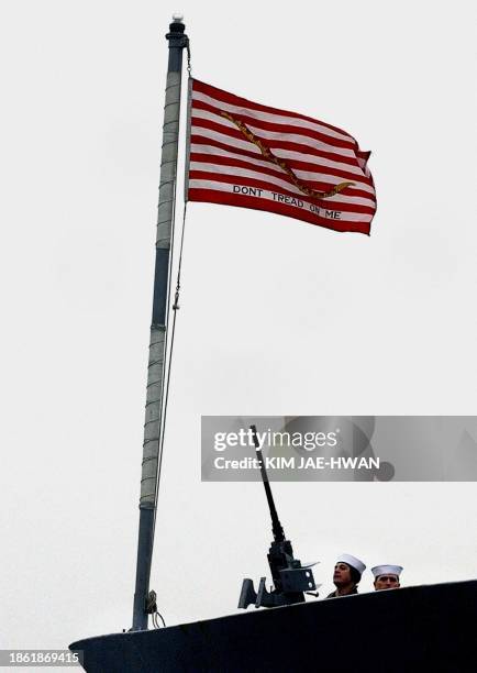 Crew of USS Vincennes man a machine gun under a US flag shortly after their ship arrived at Incheon port, 14 March 2003. The Vincennes is part of an...