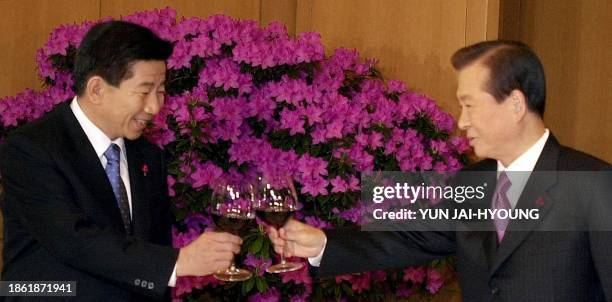 South Korean President Kim Dae-jung , and President-elect Roh Moo-hyun toast their glasses during a luncheon meeting at the presidential palace in...