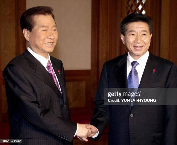 South Korean President Kim Dae-jung shakes hands with his successor, President-elect Roh Moo-hyun, during a meeting at the presidential palace in...
