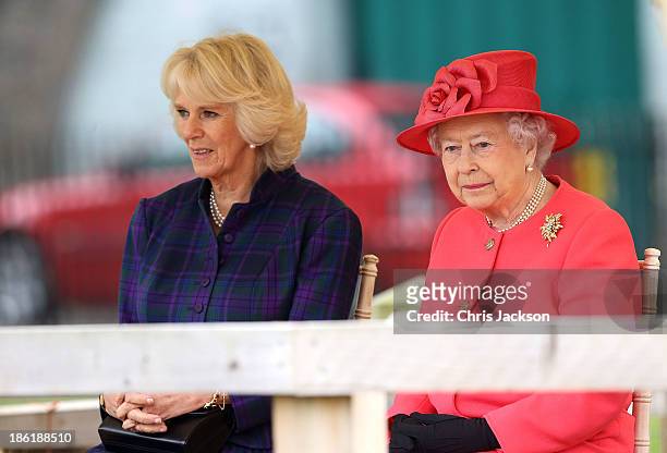 Camilla, Duchess of Cornwall and Queen Elizabeth II look on during a visit to the Ebony Horse Club & Community Riding Centre on October 29, 2013 in...