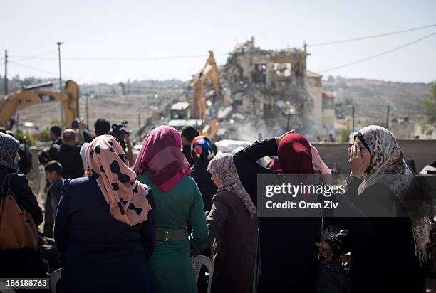 Palestinian women look on and react as Jerusalem municipality workers demolish a residential building in an East Jerusalem neighborhood on October...