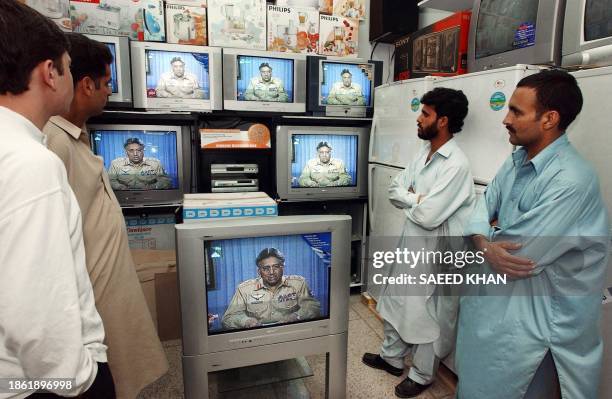 Pakistanis watch the televised national address of President Pervez Musharraf in Islamabad, 09 October 2002. President Musharraf asked the people to...