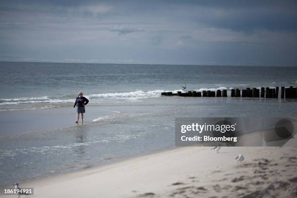 Woman walks along the beach on Long Beach Island in Long Beach Township, New Jersey, U.S., on Thursday, Sept. 26, 2013. Long Beach Township is one of...