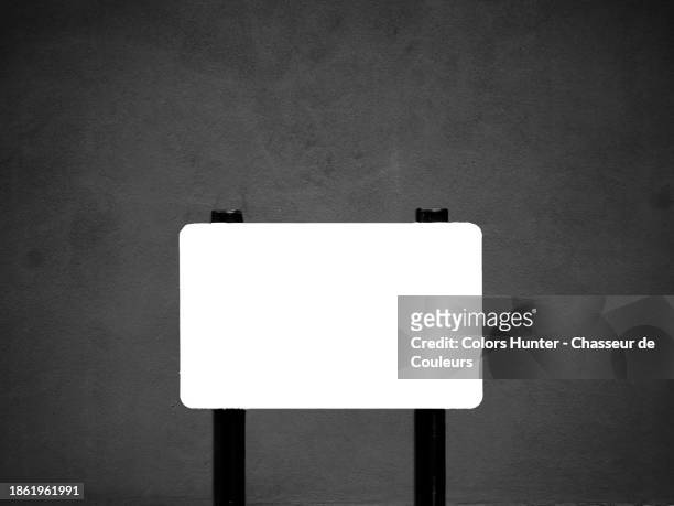 an empty and white street name sign in front of a textured gray wall in london, england, united kingdom. - commercial sign stock illustrations stock pictures, royalty-free photos & images