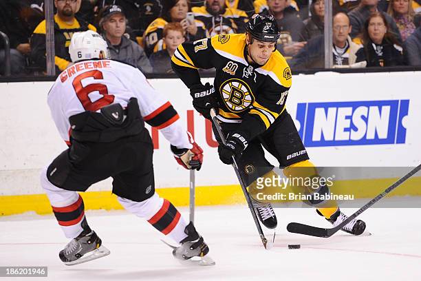 Milan Lucic of the Boston Bruins skates with the puck against Andy Greene of the New Jersey Devils at the TD Garden on October 26, 2013 in Boston,...