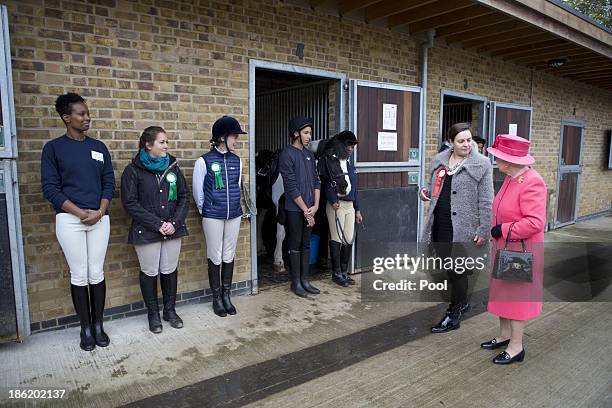 Queen Elizabeth II is given a tour by Miss Ros Spearing, Director of Ebony Horse Club & Community Riding Centre, during an official visit on October...