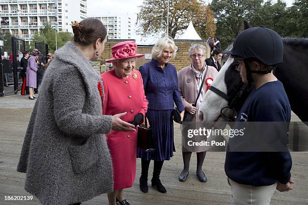 Queen Elizabeth II and Camilla, Duchess Of Cornwall are given a tour by Miss Ros Spearing, Director of Ebony Horse Club & Community Riding Centre,...