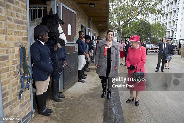 Queen Elizabeth II is given a tour by Miss Ros Spearing, Director of Ebony Horse Club & Community Riding Centre, during an official visit on October...