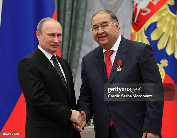 Russian President Vladimir Putin shakes hands with billionaire Alisher Usmanov during an awards ceremony at the Kremlin October 29, 2013 in Moscow,...