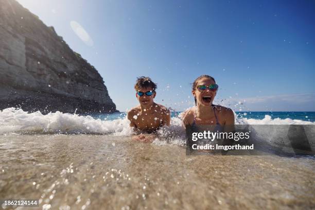 teenagers enjoying the cold springtime sea - tween girls swimwear stock pictures, royalty-free photos & images