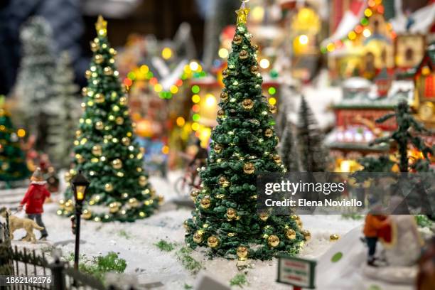 toy christmas tree with lights in snow outside in toy town. new year christmas card - tradition town square stock pictures, royalty-free photos & images