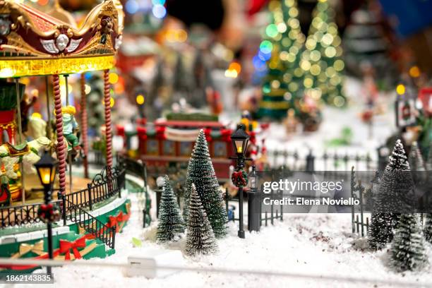 toy christmas tree with lights in snow outside in toy town. new year christmas card - tradition town square stock pictures, royalty-free photos & images