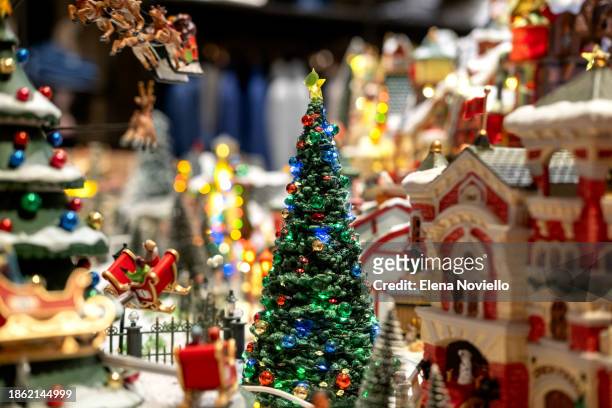 toy christmas tree with lights in snow outside in toy town. new year christmas card - tradition town square stock pictures, royalty-free photos & images