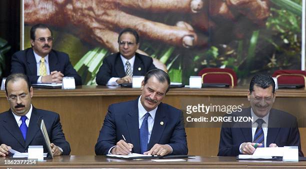 President Vicente Fox is seen signing documents regarding the farming sector alongside Armando Salinas Torre and Enrique Jackson during ceremonies in...