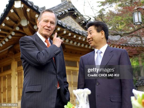 Former US president George Bush listens to South Korean President Roh Moo-Hyun at the presidential Blue house in Seoul, 15 April 2003. The former US...