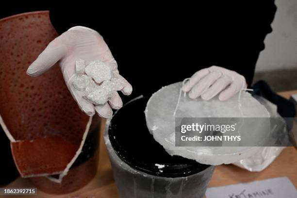 Belgian customs officer presents shows Ketamine hidden in a flower pot during a press conference to present the drug seizures of 2023 at Brussels...