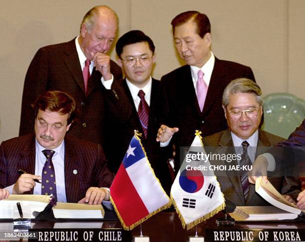 South Korean Foreign Minister Choi Sung-hong and his Chilean countpart Cristian Barros sign documents of bilateral free trade agreement in front of...