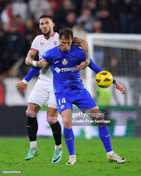 Nemanja Gudelj of Sevilla FC competes for the ball with Juan Miguel Latasa of Getafe CF during the LaLiga EA Sports match between Sevilla FC and...
