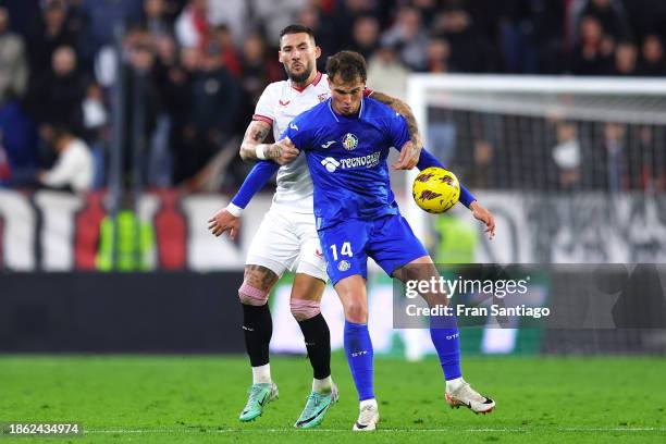 Nemanja Gudelj of Sevilla FC competes for the ball with Juan Miguel Latasa of Getafe CF during the LaLiga EA Sports match between Sevilla FC and...