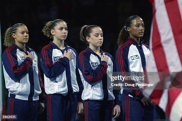 Ashley Postell, Courtney Kupets, Carly Patterson and Annia Hatch of the United States women's team reflect during the National Anthem at the 2003...